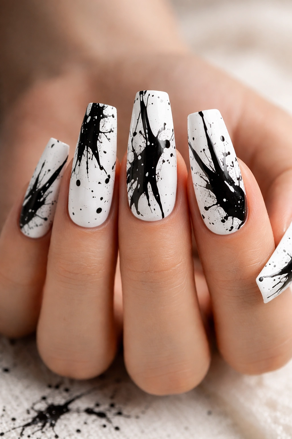 Coffin nails featuring black splatter abstract art on a white base