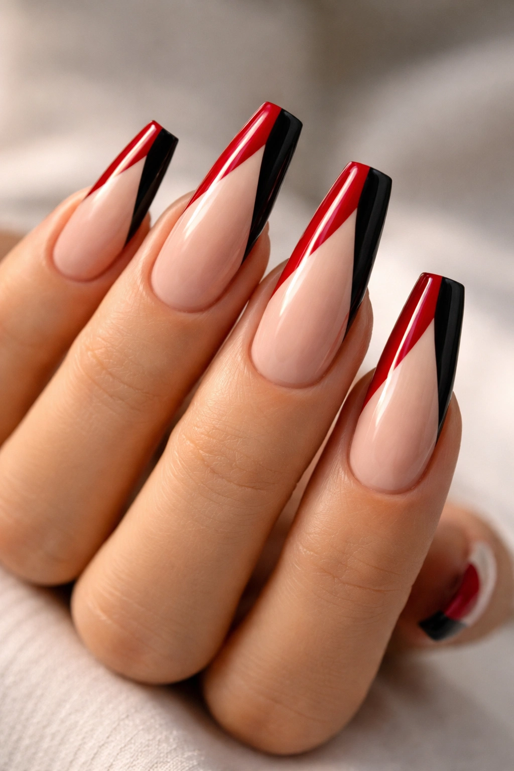 Long ballerina nails with diagonal split black and red French tips on nude base