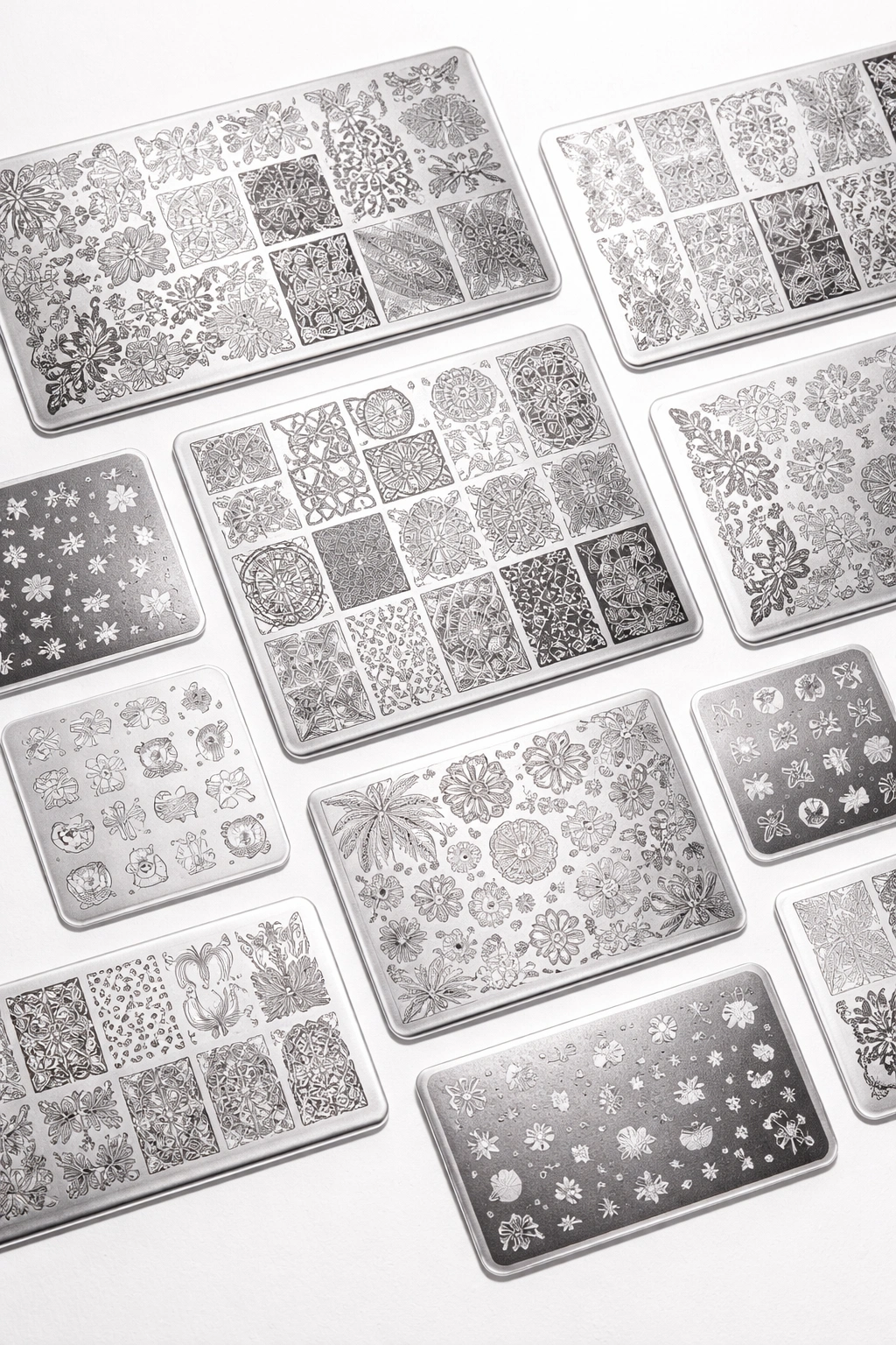 Assorted stamping plates with varied patterns displayed on a plain background