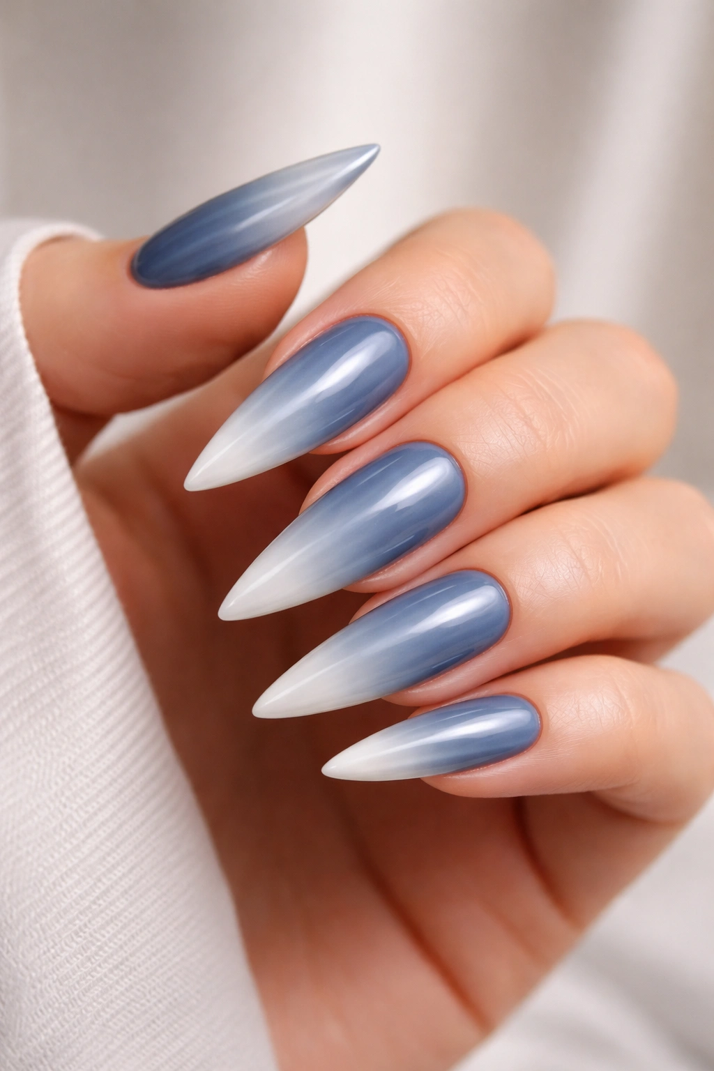 Steel blue nails with a white gradient ombre tip on stiletto shape
