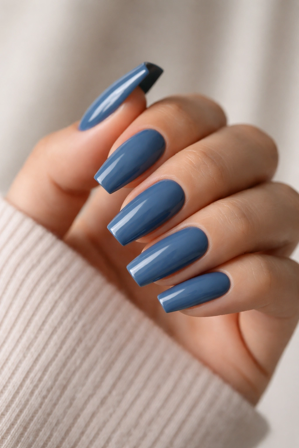 Close-up of medium coffin nails painted steel blue with glossy finish