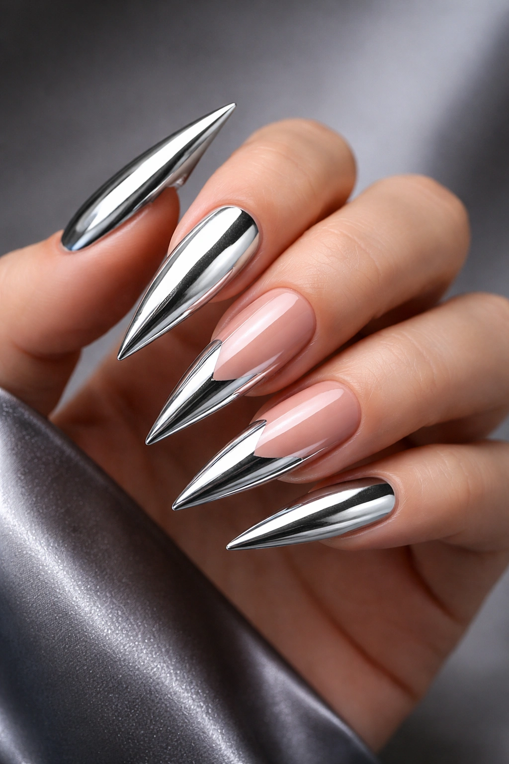 Close-up of stiletto chrome-accented nails with a dramatic sharp point.
