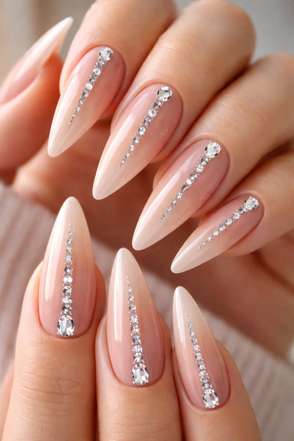 Close-up of nude stiletto nails with a center diamond cascade
