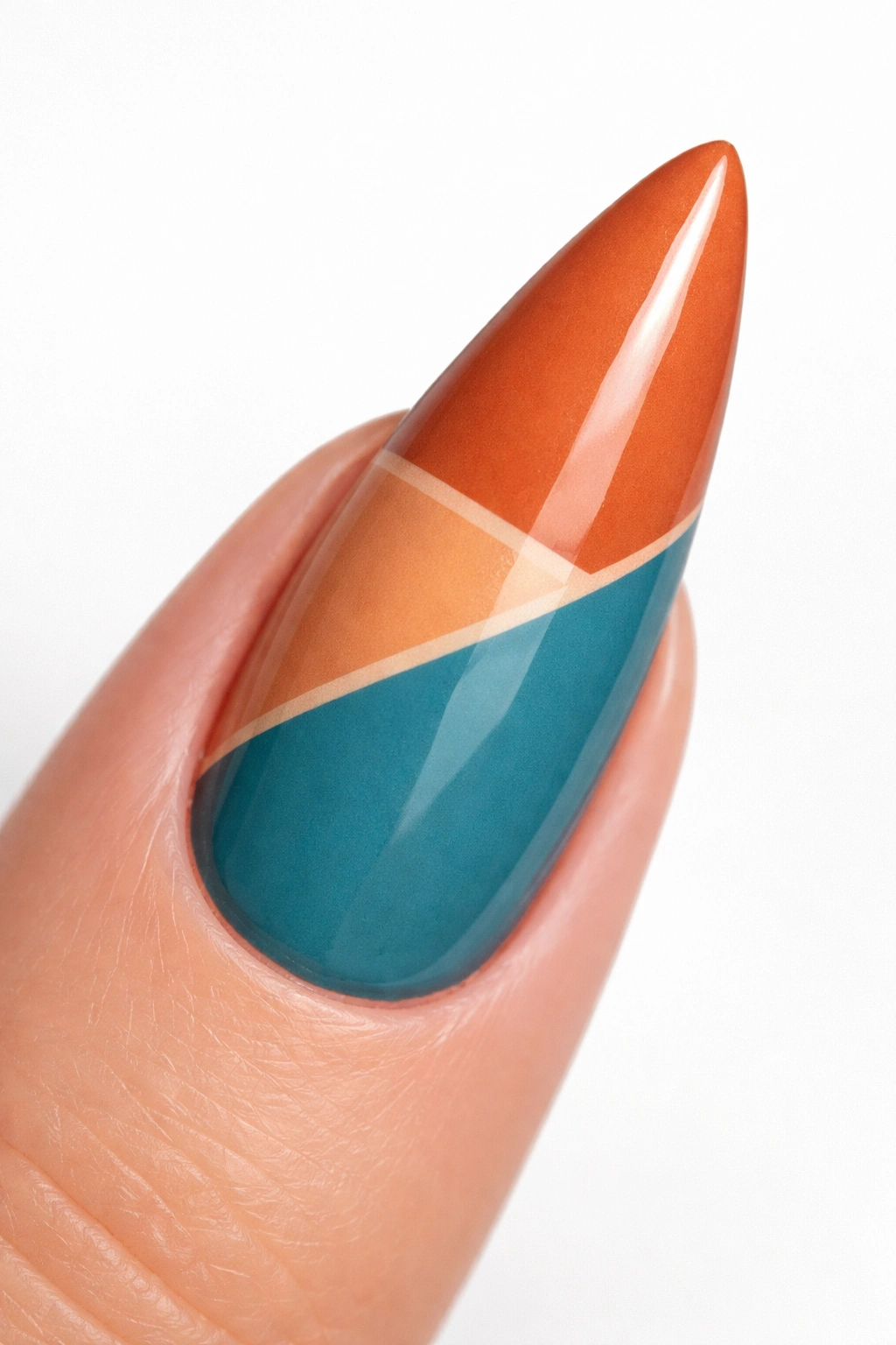 Close-up of a stiletto nail with color-blocked terracotta orange and teal blue