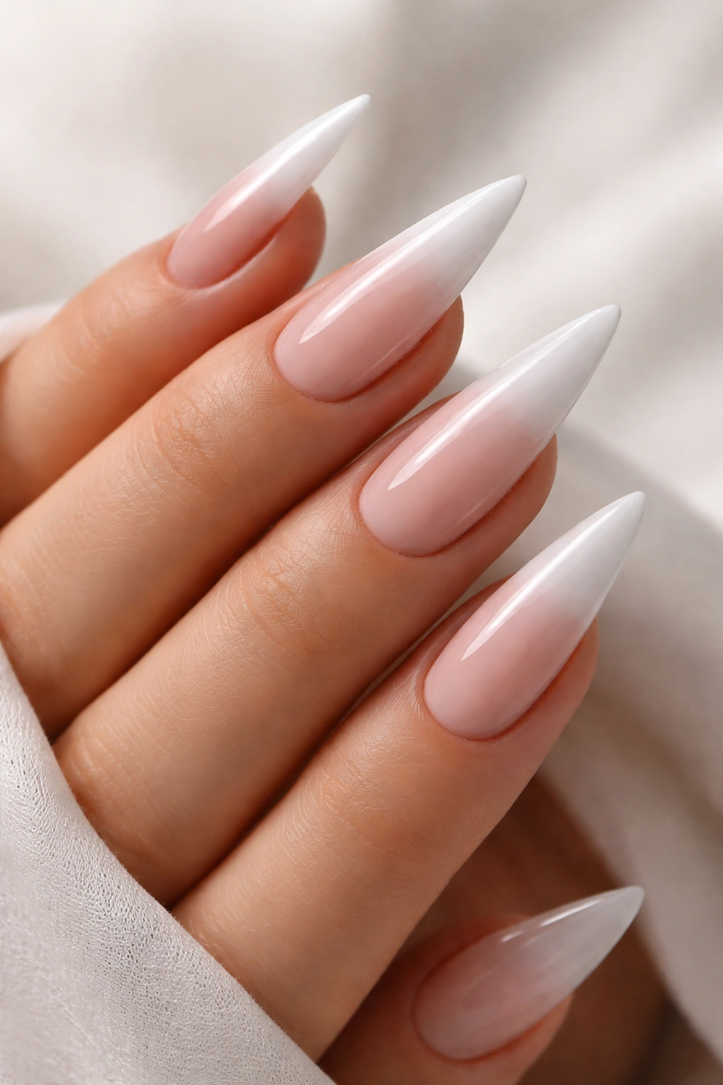 Close-up of stiletto nails with a soft ombré gradient from base to tip