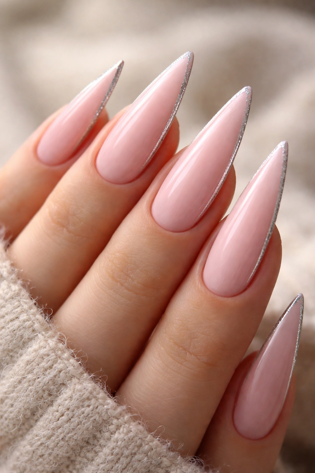 Pale pink stiletto nails with a thin silver sparkle line