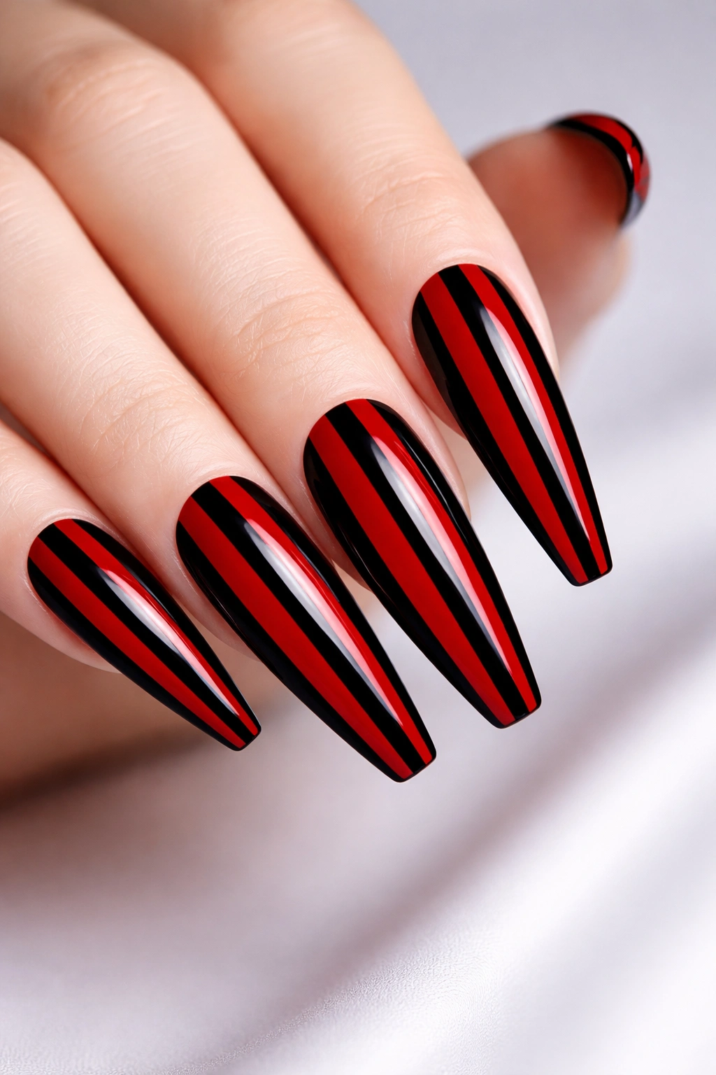 Close-up of nails with red and black vertical stripes