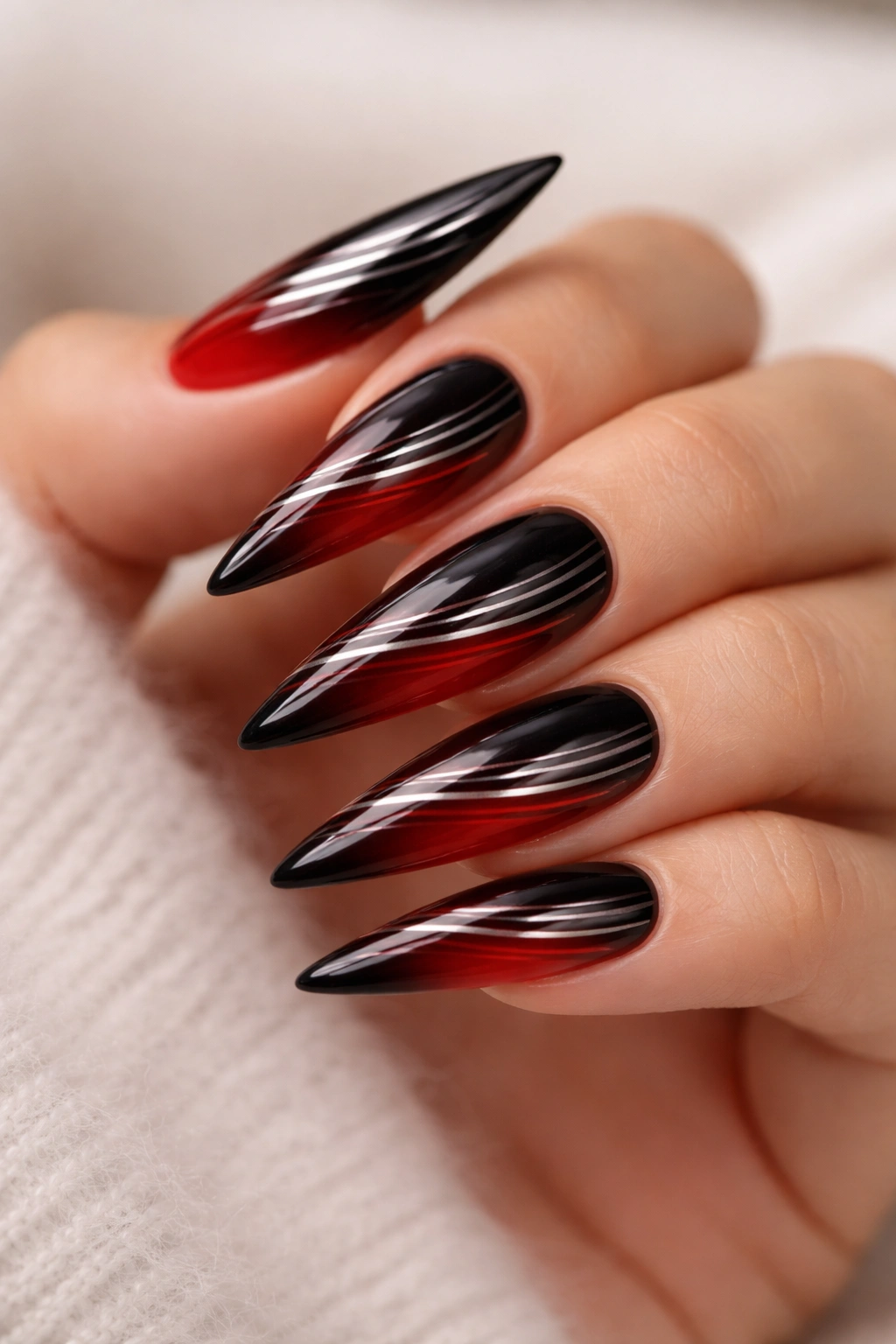 Close up of striped ombre nails on black-to-red gradient