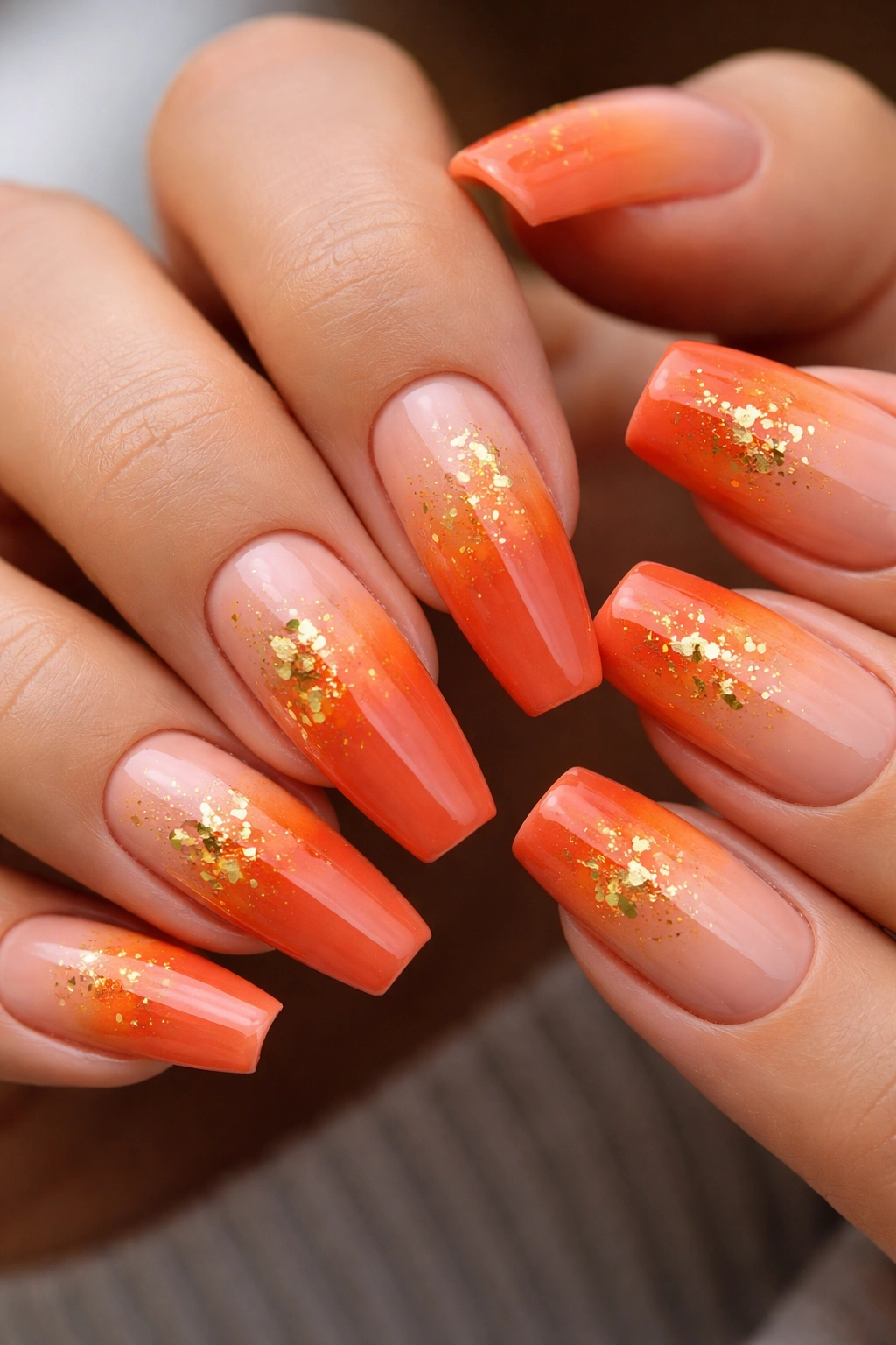 Nails with sunset ombré gradient and gold foil accents on ballerina shape