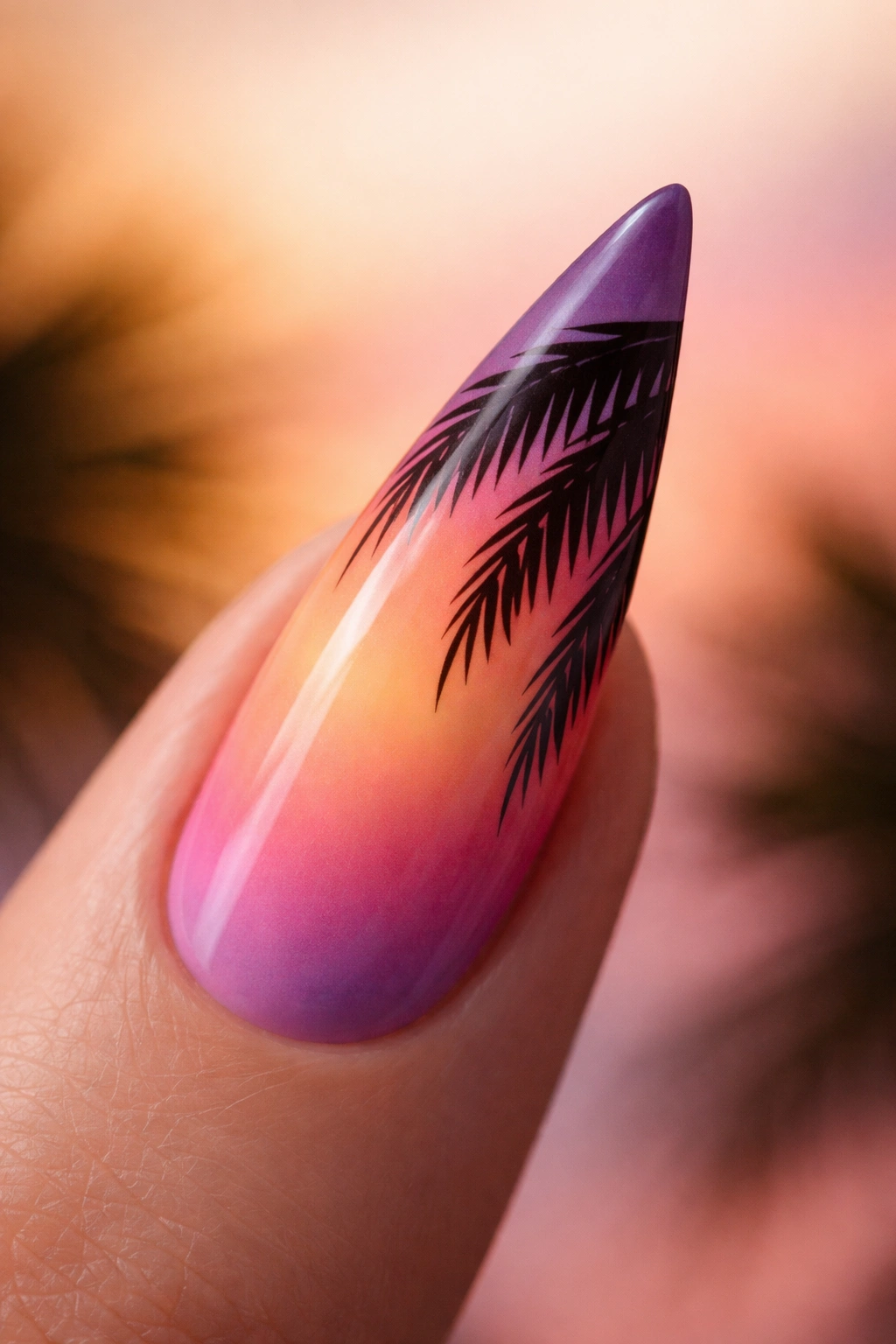 Stiletto nail with sunset gradient and dark palm frond silhouettes at tip
