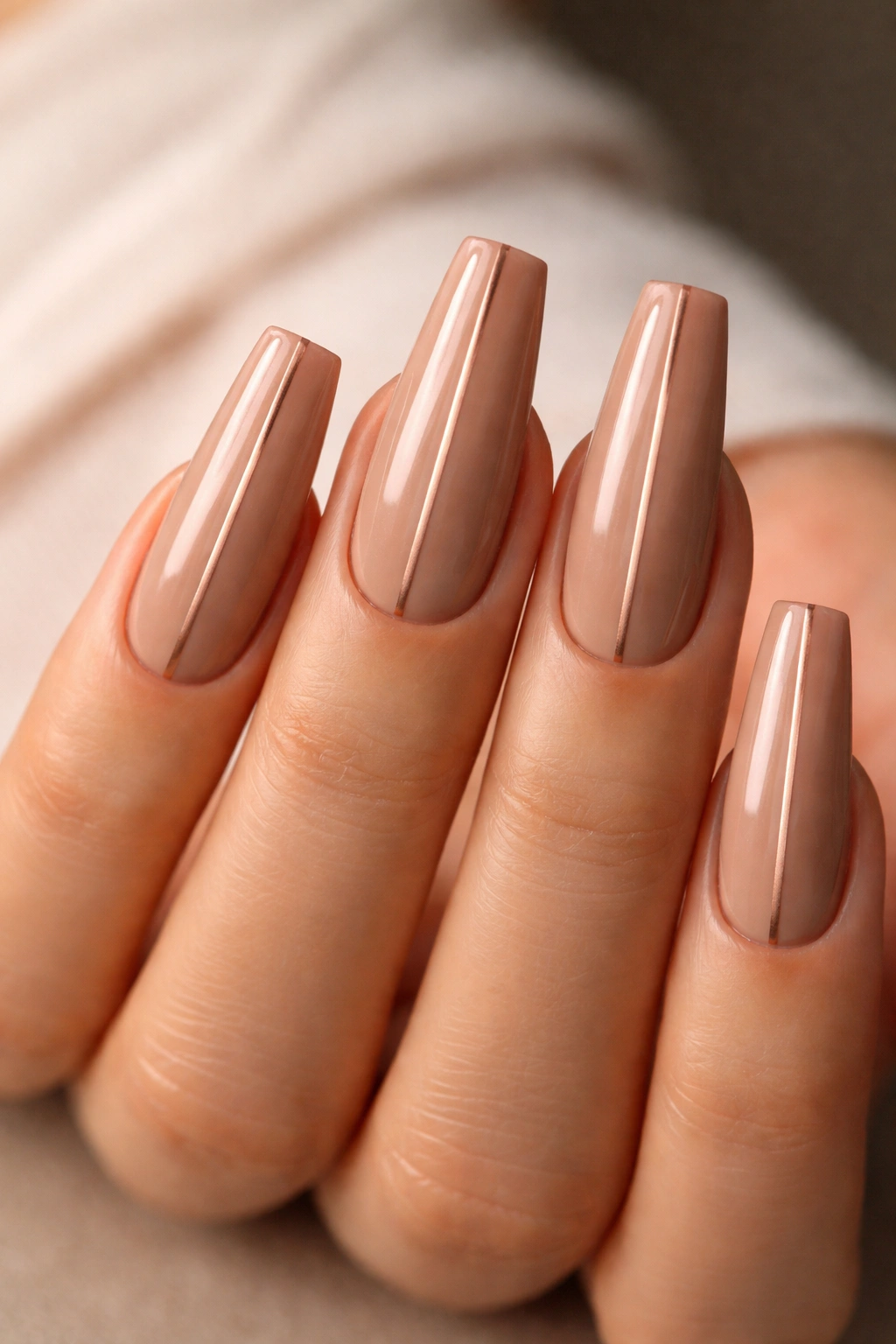 Warm tan coffin nails with a centered rose-gold stripe