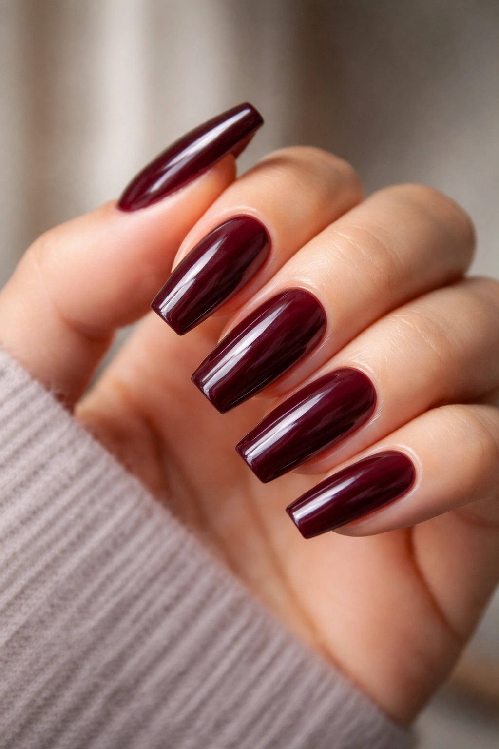Close-up of burgundy ballerina nails with tapered sides and flat tips
