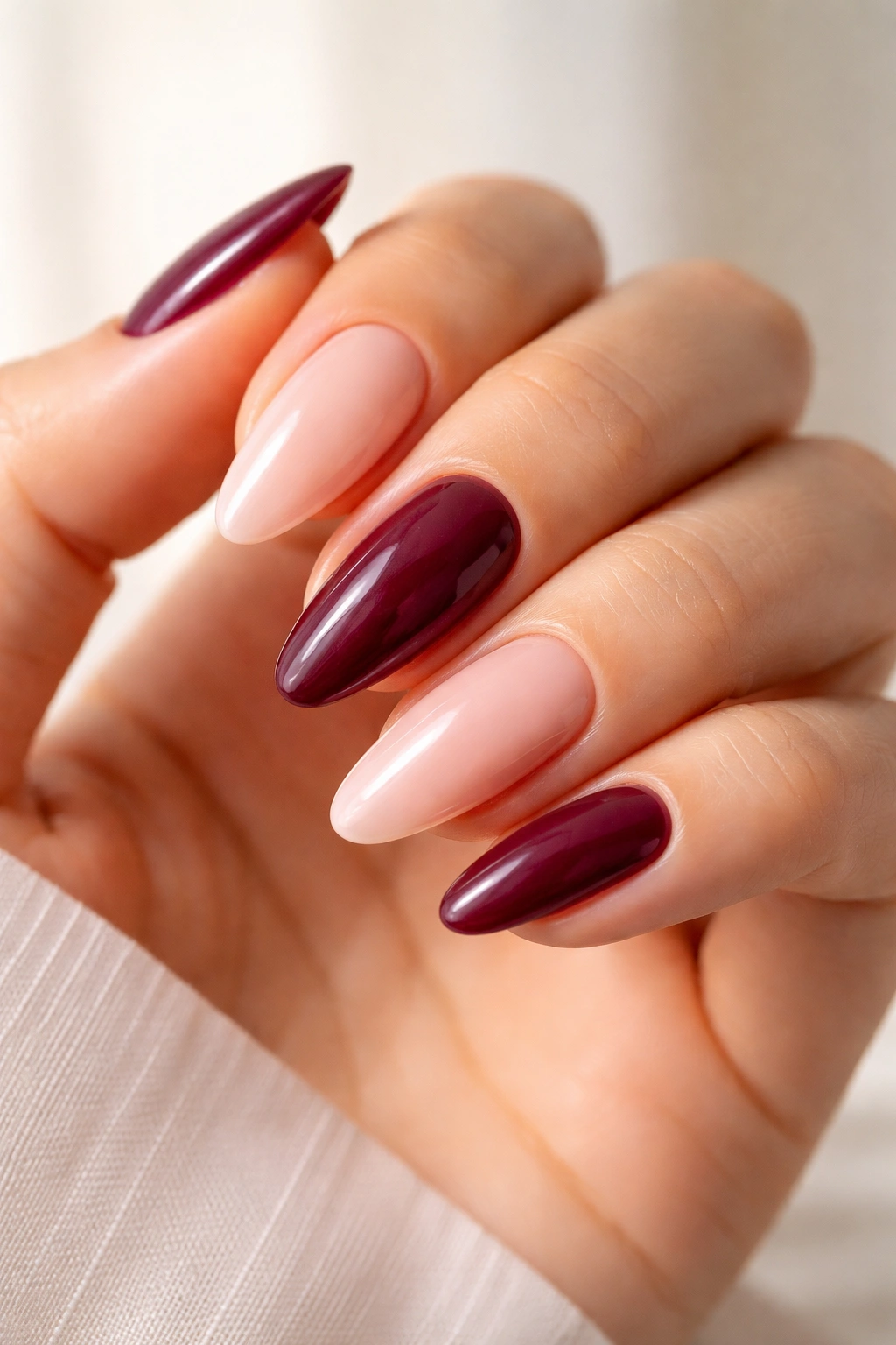 Close-up of almond oval nails in nude and berry shades showing flattering color options for tapered nails