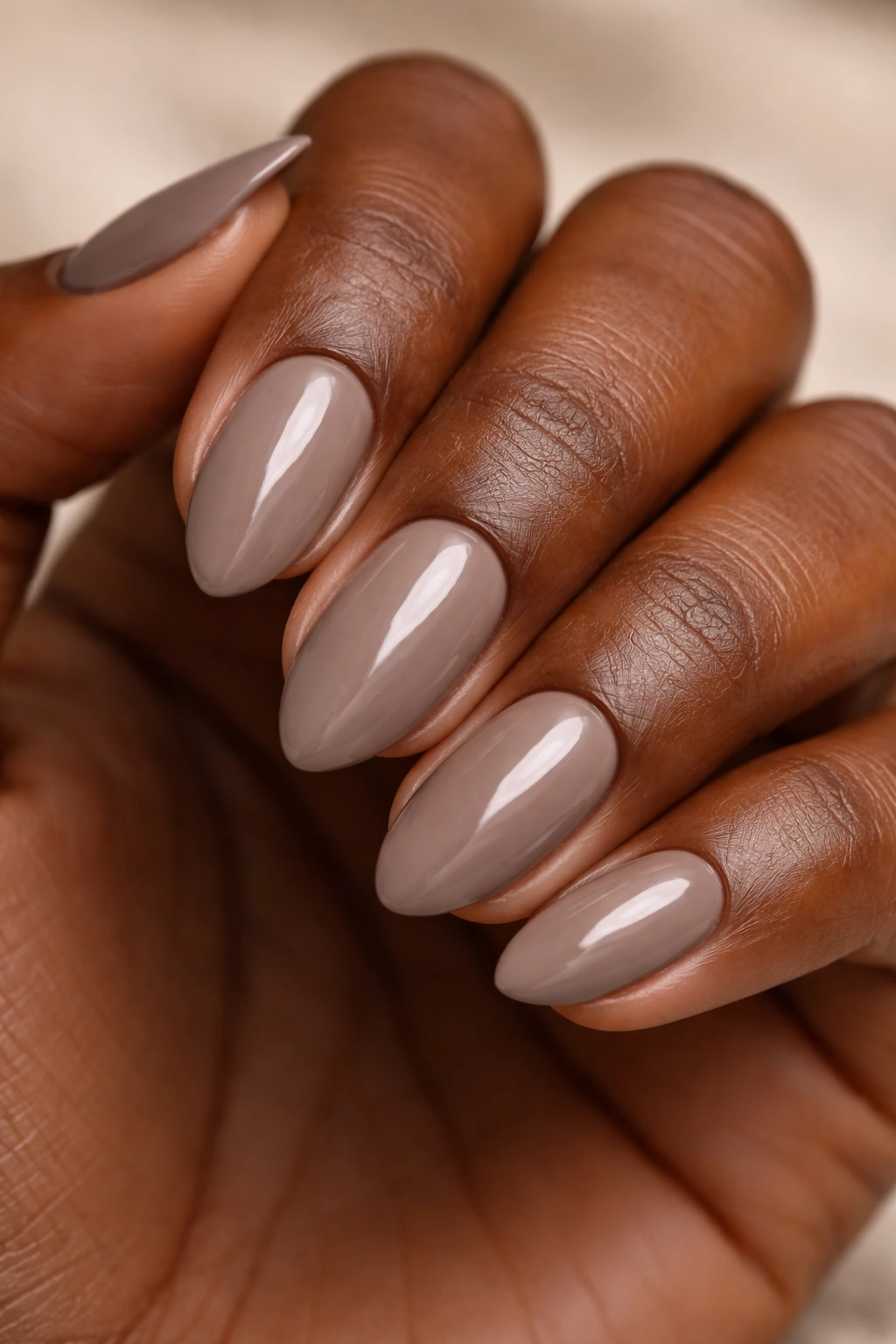 Close-up of warm taupe short almond nails