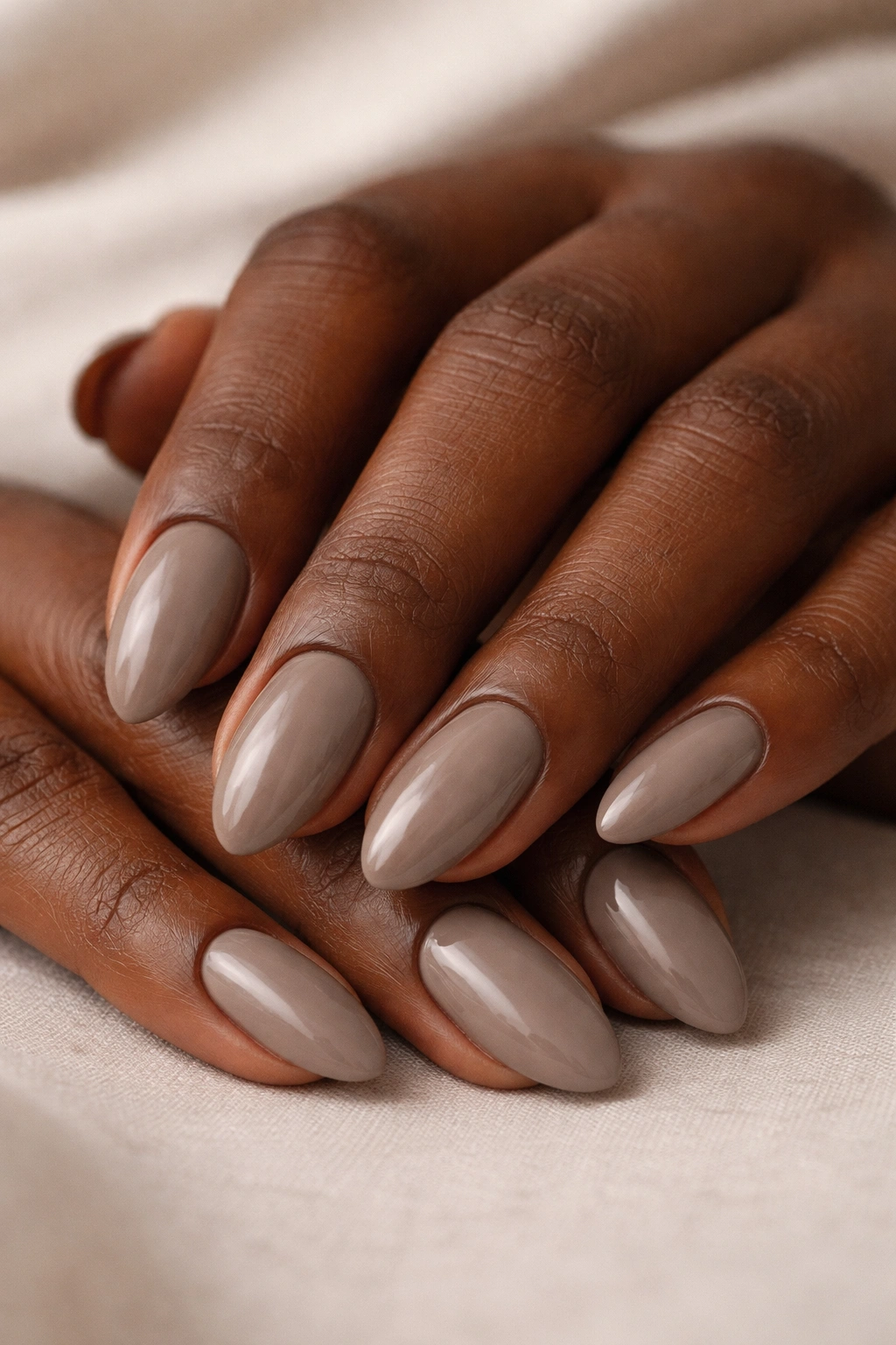 Close-up of taupe brown almond nails on a hand