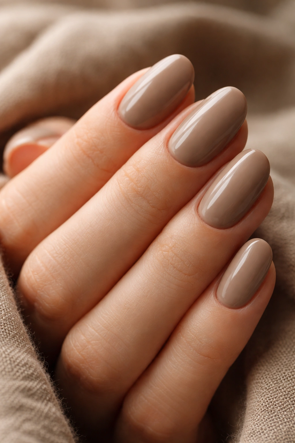 Close-up of taupe brown short oval nails in a dusty earth tone