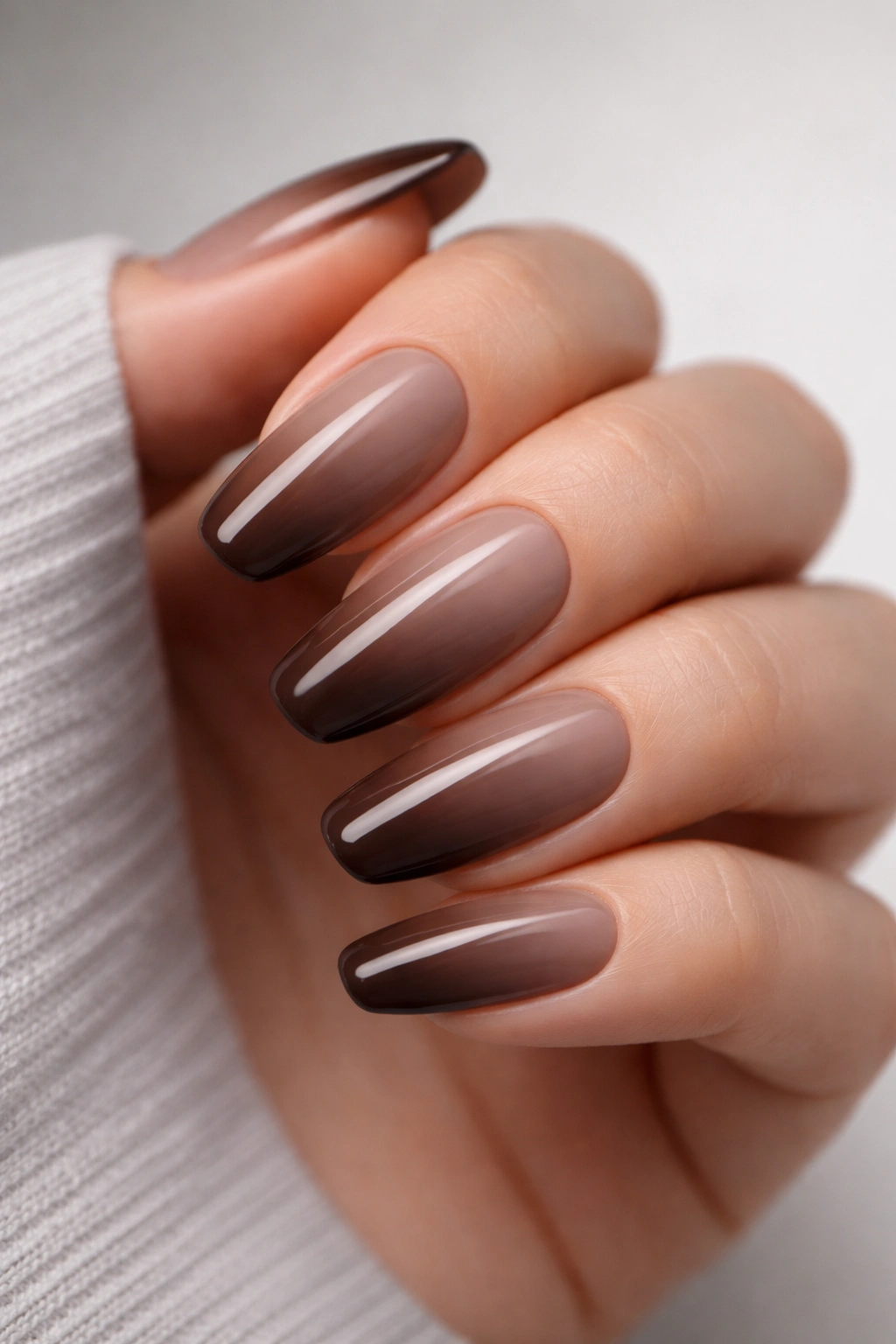 Close-up of nails with a cool taupe-to-chocolate ombre gradient