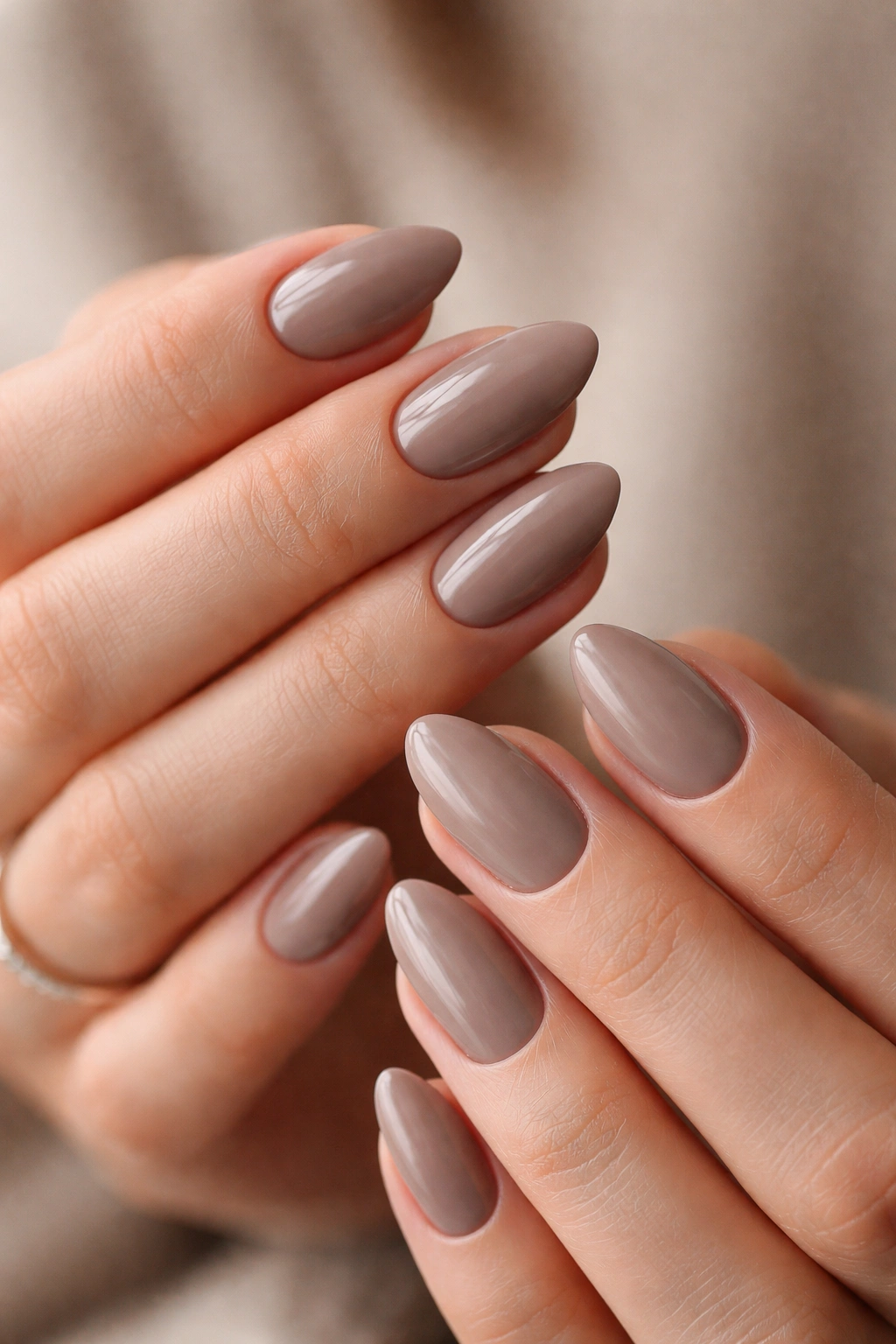 Close-up of hands showing taupe short almond nails