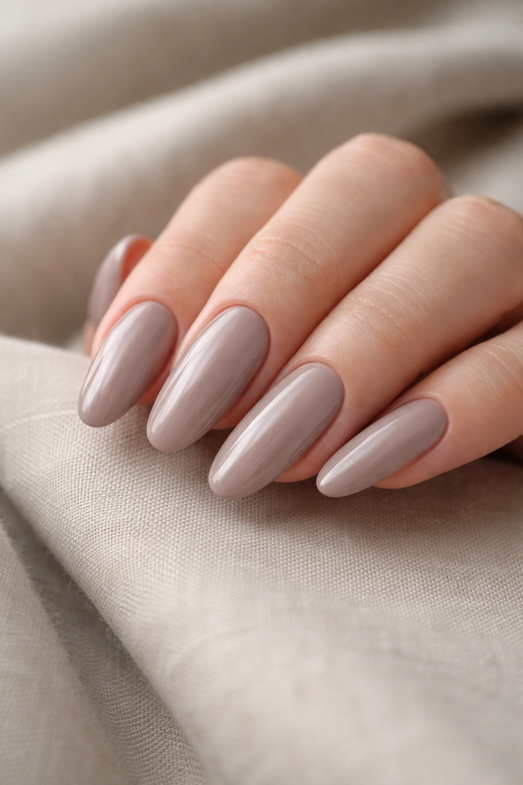 Close-up of glossy taupe long-oval nails