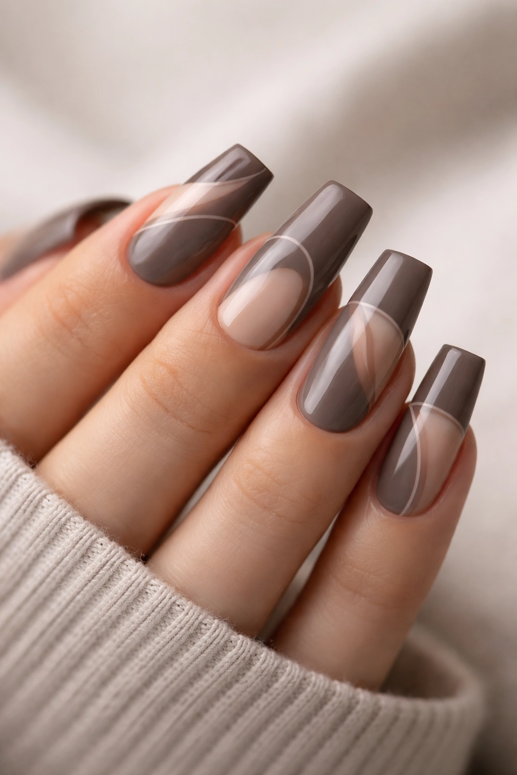 Close-up of deep taupe medium duck nails featuring negative-space patterns