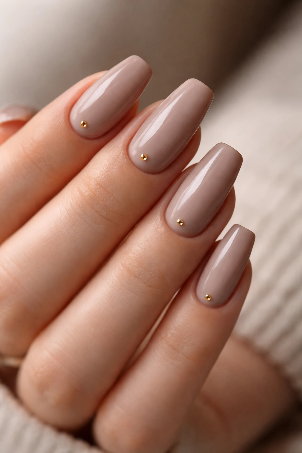 Taupe nails with tiny gold studs on accent nail