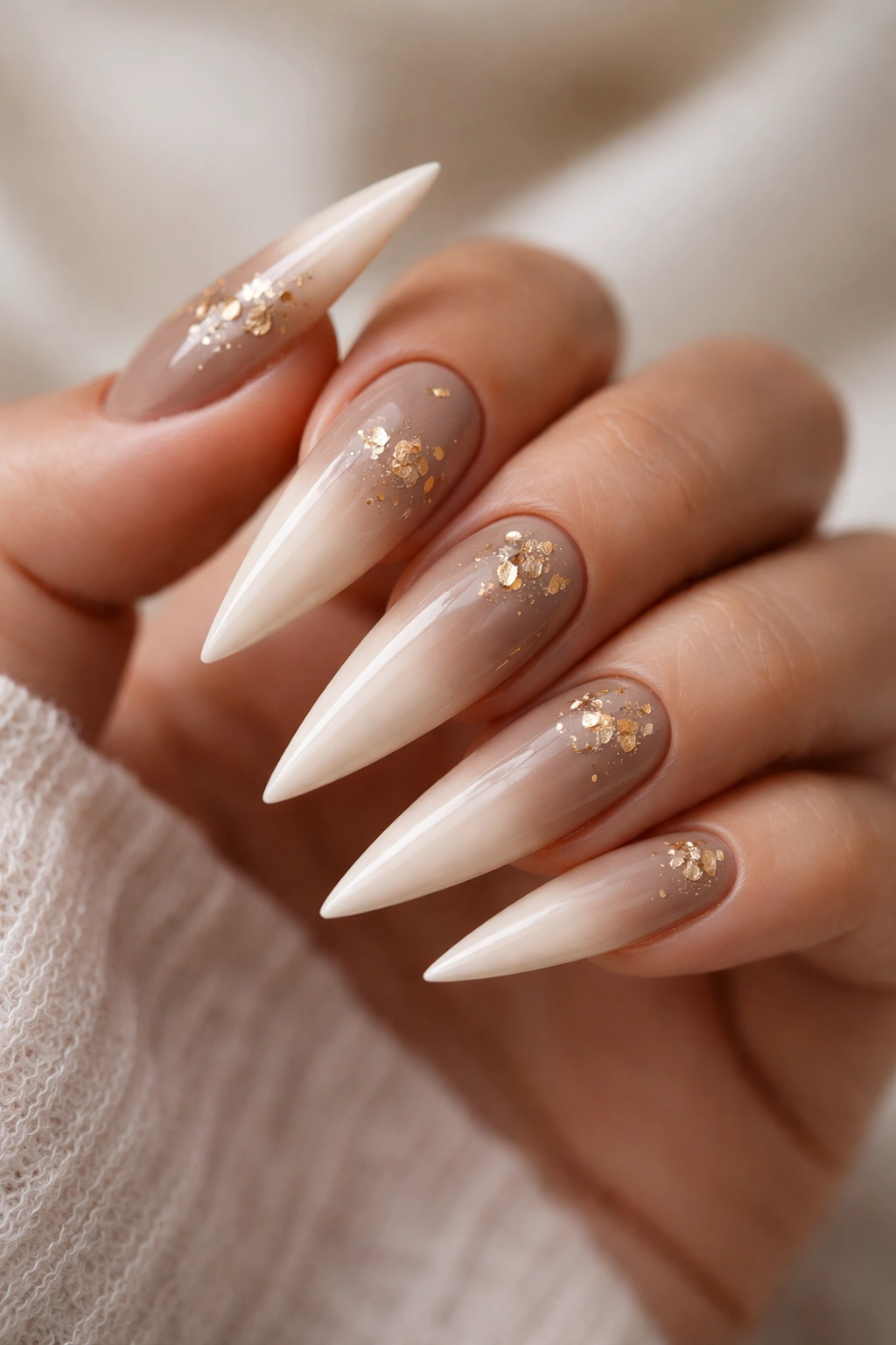 Stiletto nails with taupe to cream ombre and subtle gold leaf accents