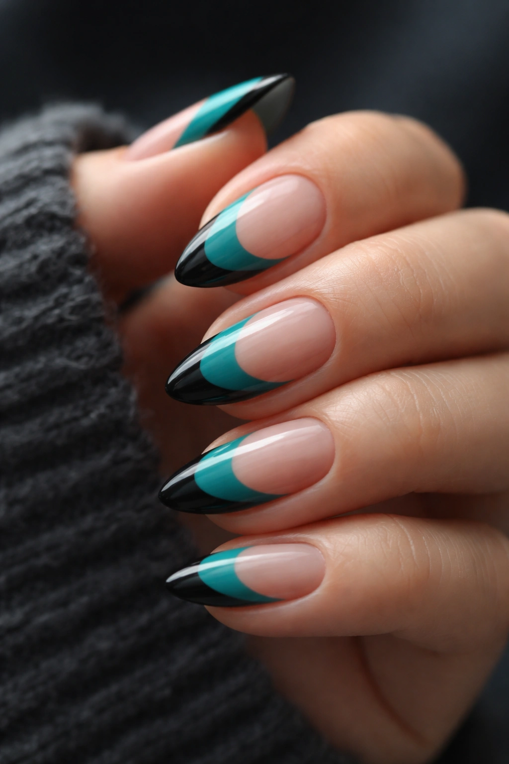 Short almond nails with teal and black tips in a crisp design