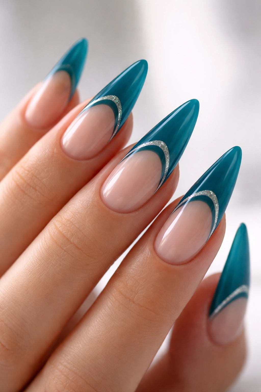 Close-up of teal blue reverse French tip stiletto nails near the cuticle
