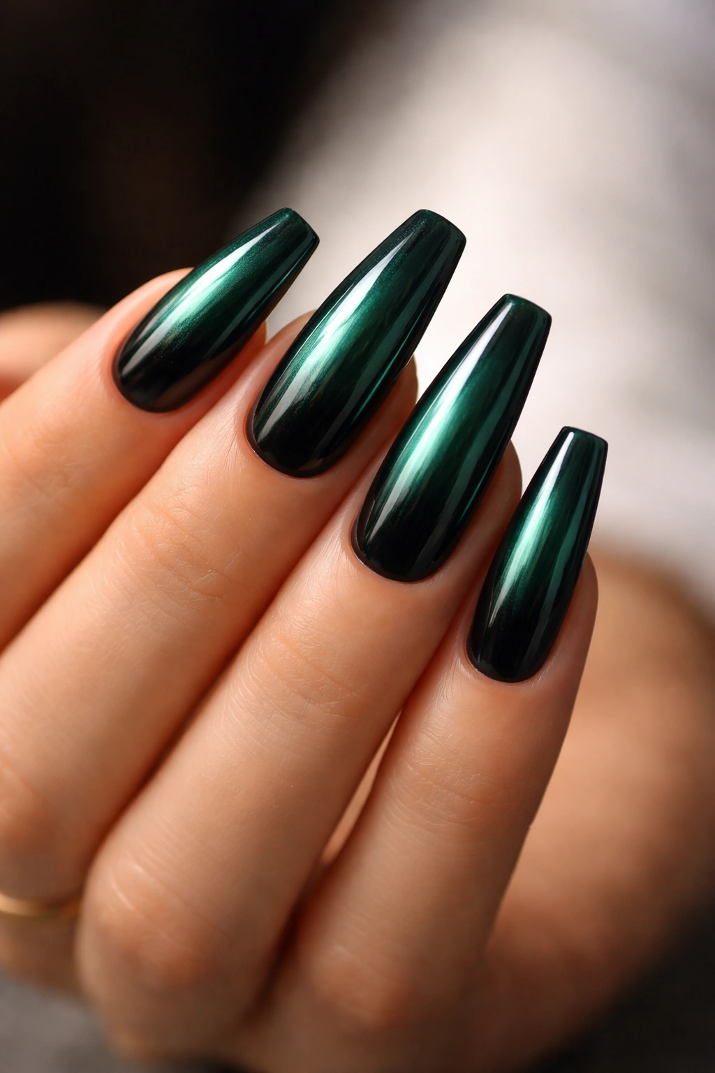 Deep teal-green chrome nails over black gel.