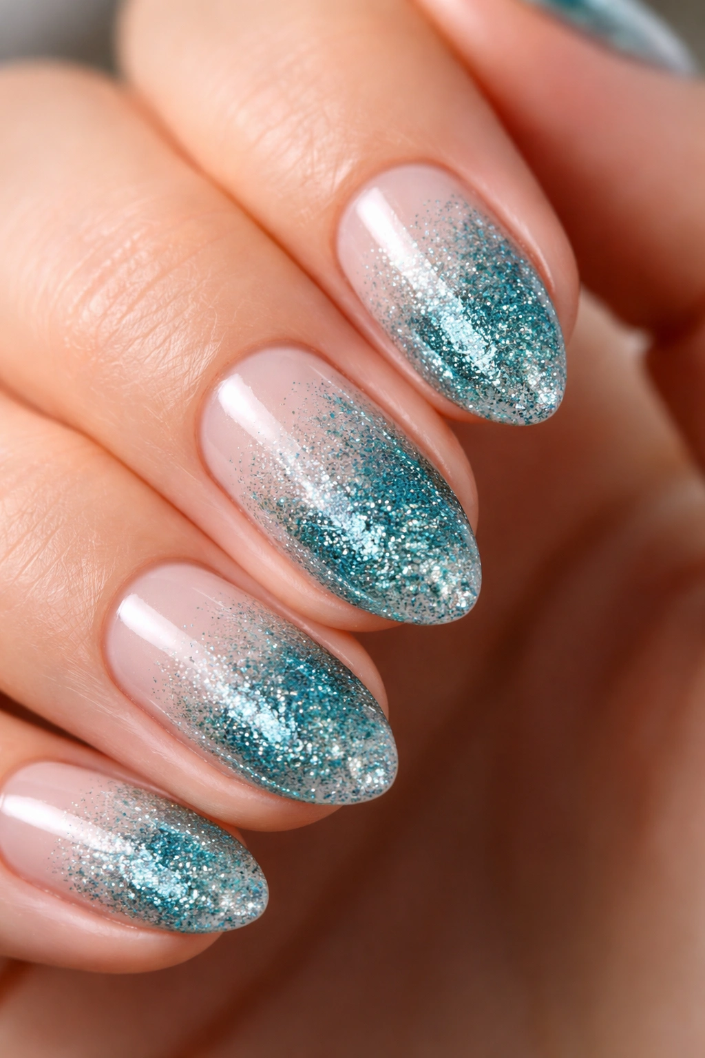 Short almond nail with teal glitter gradient from cuticle to tip
