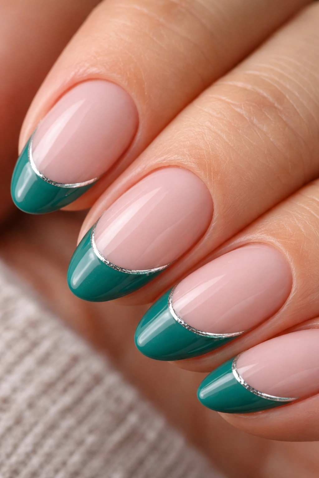 Close-up of a short almond nail with teal-green tip and silver line along the smile line