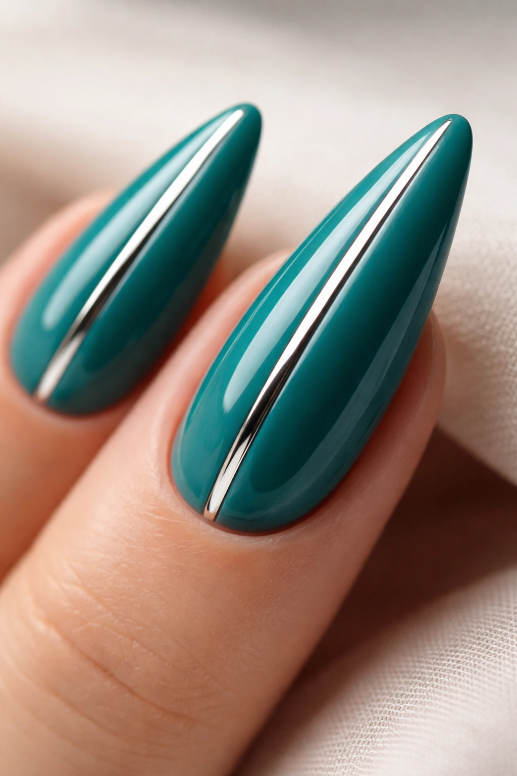 Close-up of teal stiletto nails with a centered chrome stripe
