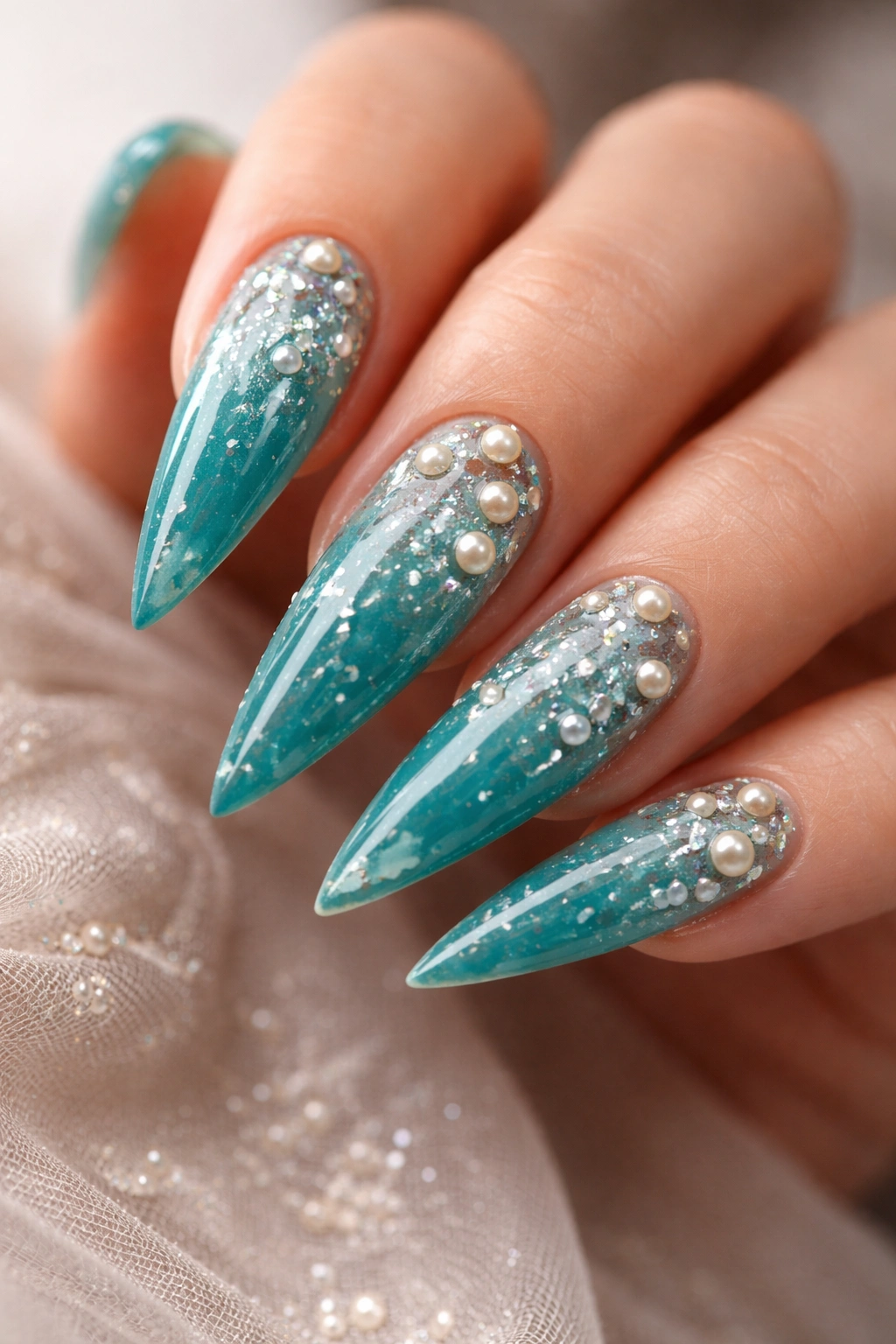 Teal nails with pearl inlays on stiletto tips