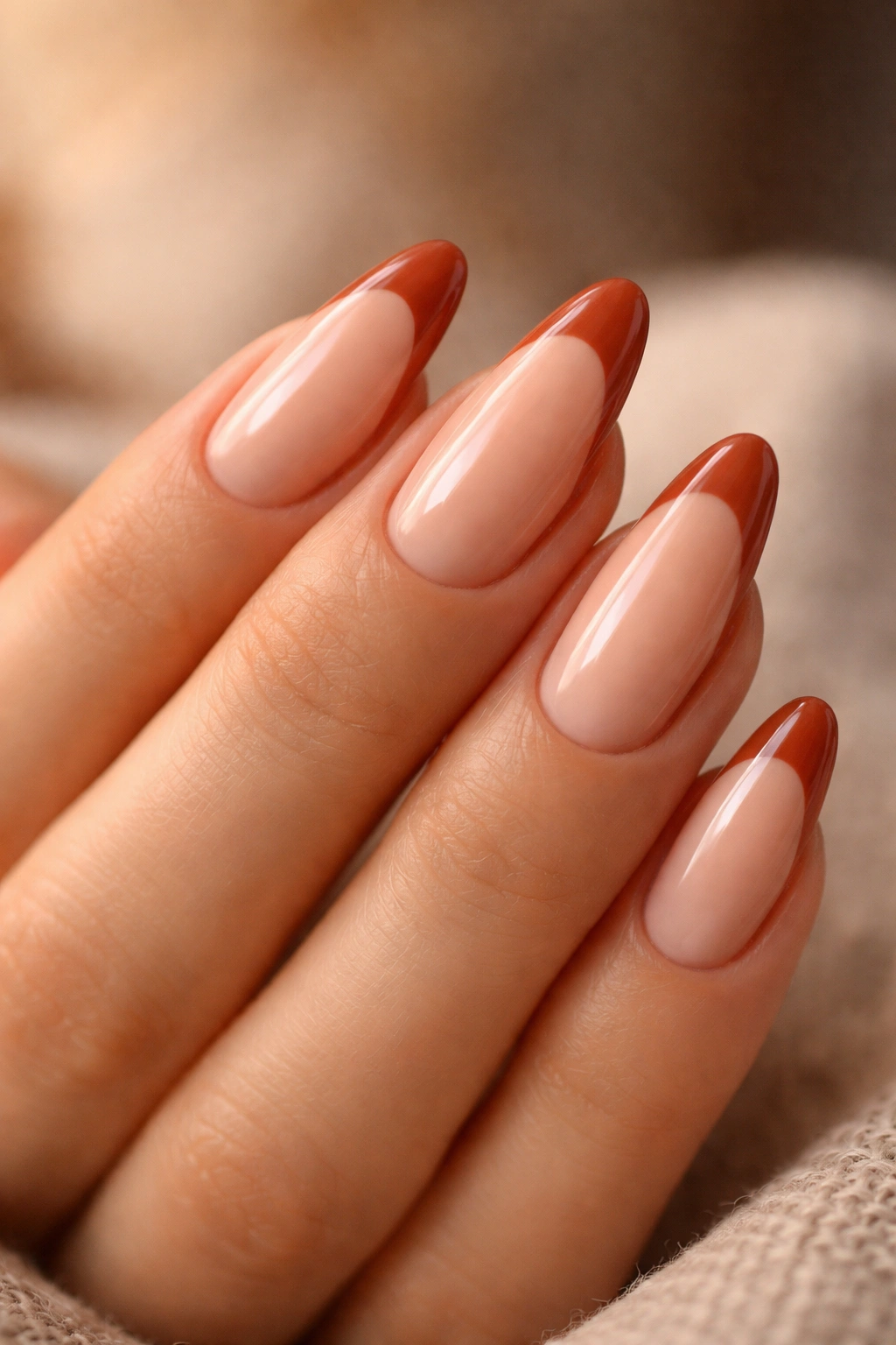 Almond nails with terracotta tips on soft peach base