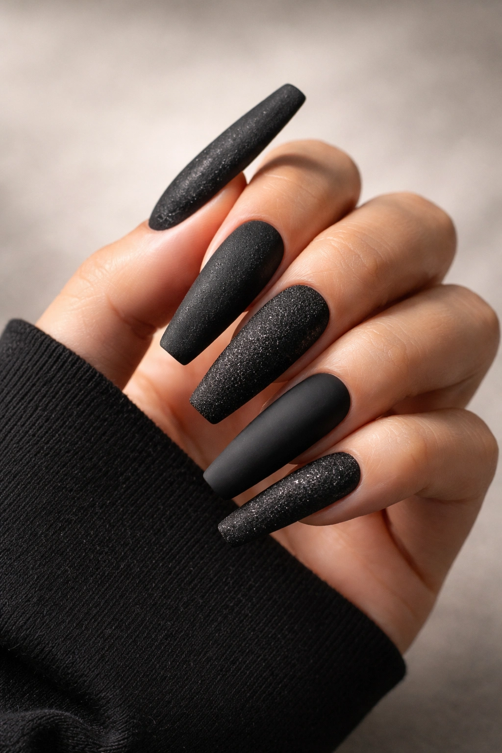 Close-up of textured black coffin nails showing suede velvet or matte textures