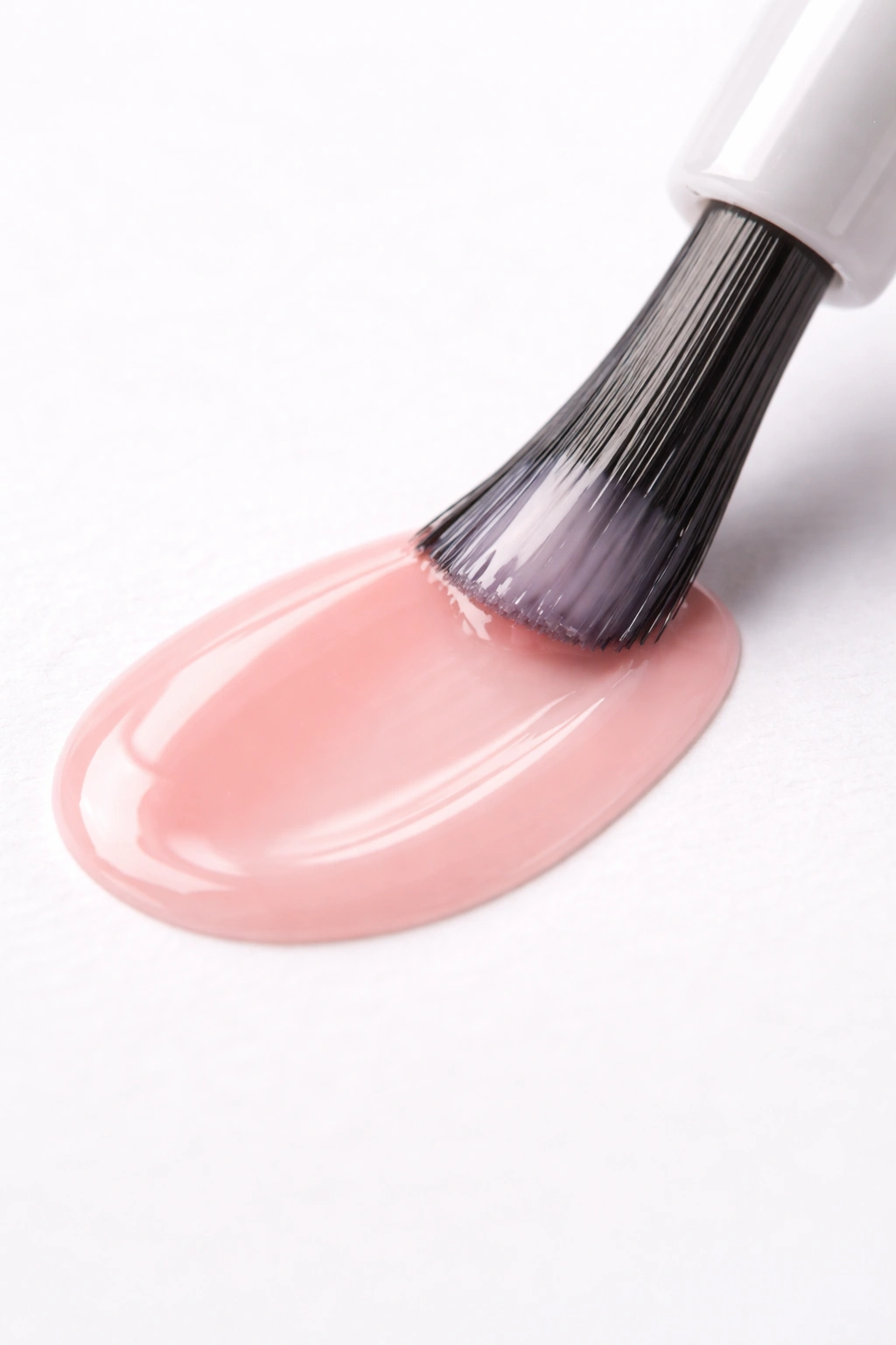 Polish brush applying thin coat to color swatch