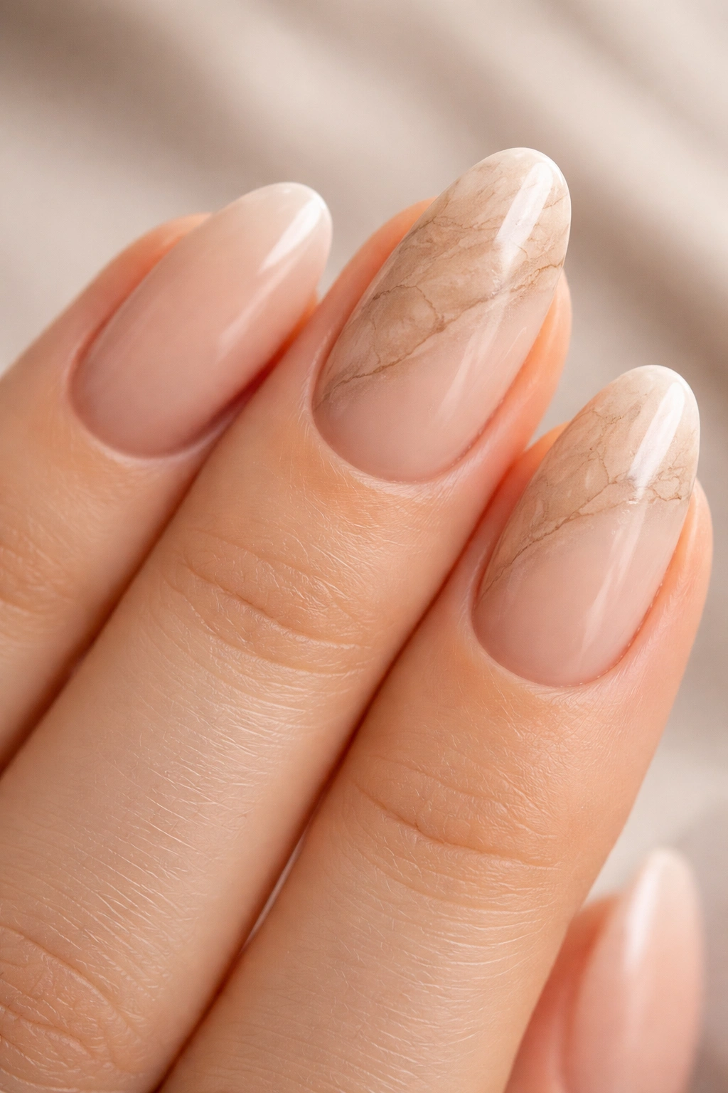 Close-up of tonal marble detail on accent nails with sheer nude base