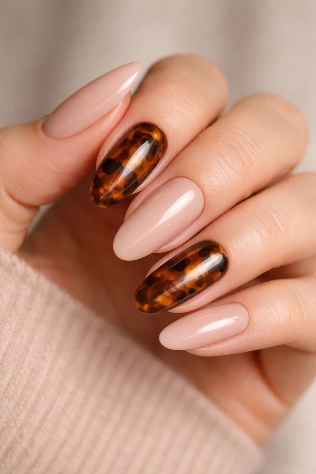 Close-up of long oval nails with tortoiseshell pattern on accent nails
