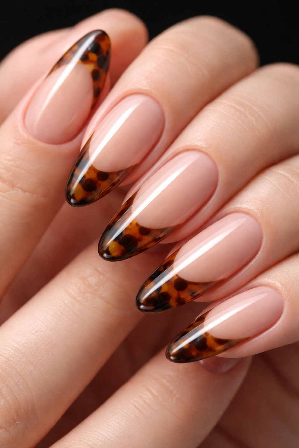 Close-up of almond nail with tortoiseshell tip on nude base, macro