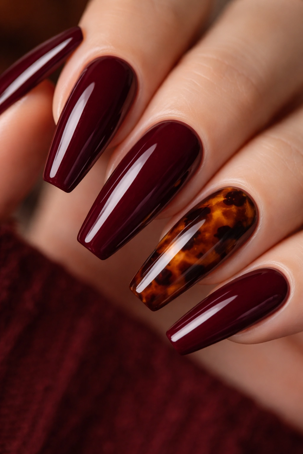Burgundy nails with tortoiseshell accent on one finger