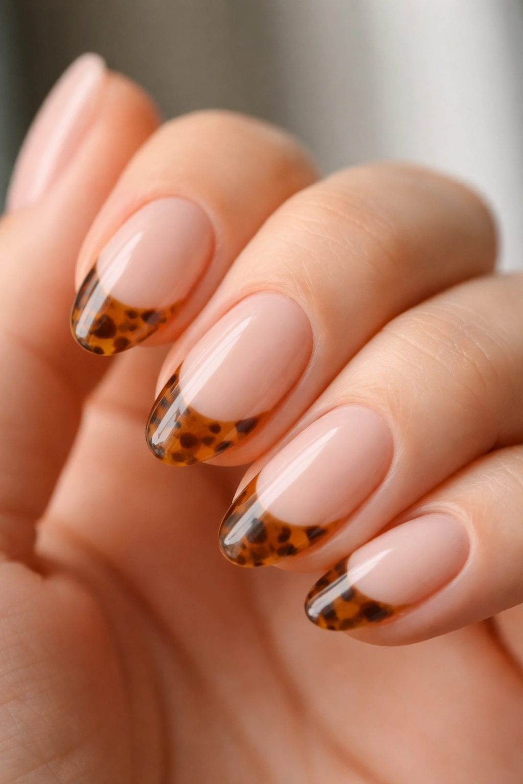 Close-up of a short almond nail with tortoiseshell marbling on the tip