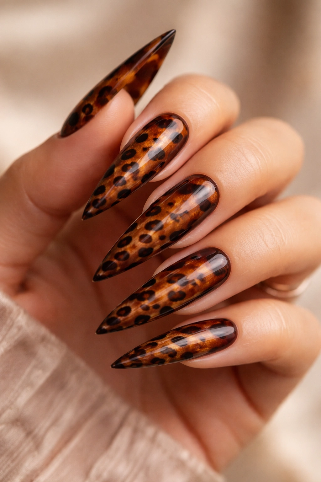 Macro close-up of tortoiseshell-inspired leopard-print stiletto nails in warm brown tones