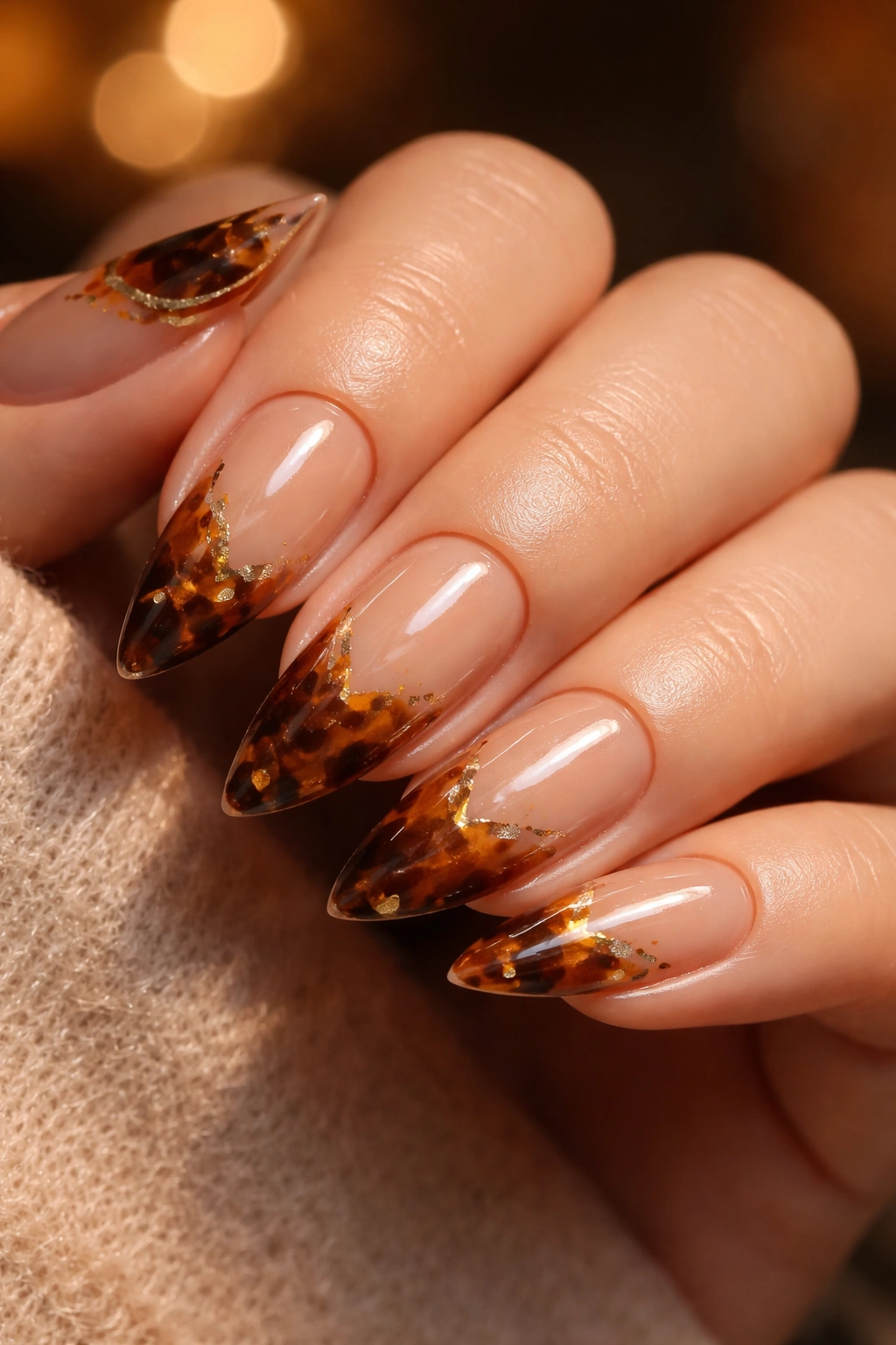 Tortoiseshell almond nails with warm amber and gold accents.