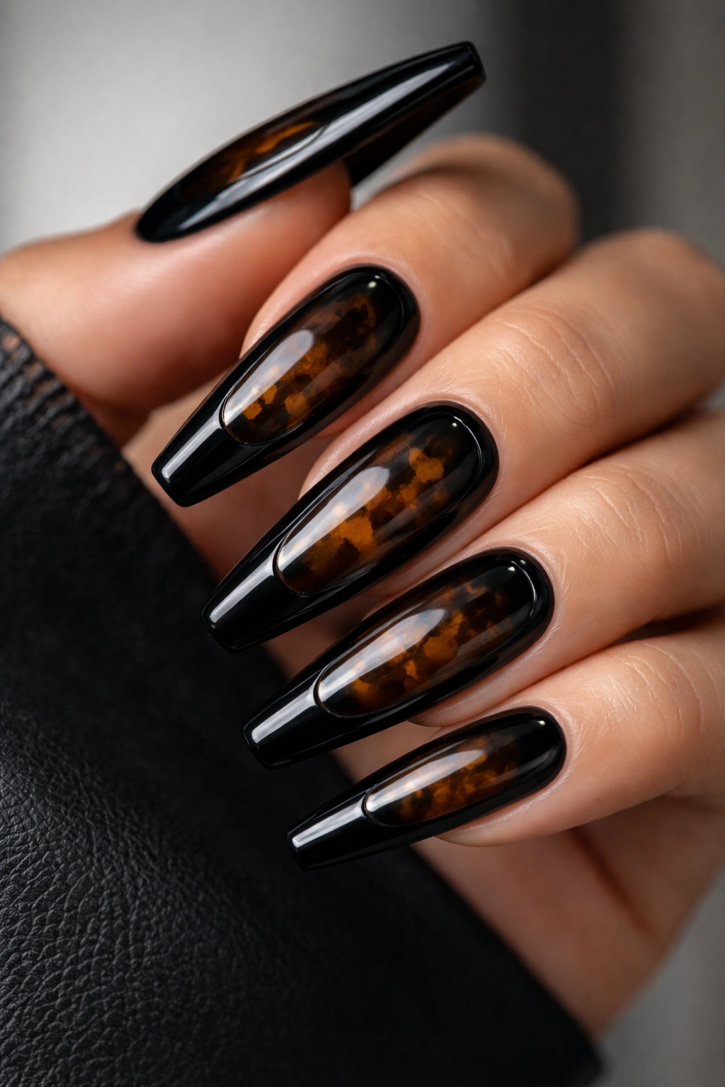 Nails with black base and dark tortoiseshell windows framed in gloss black