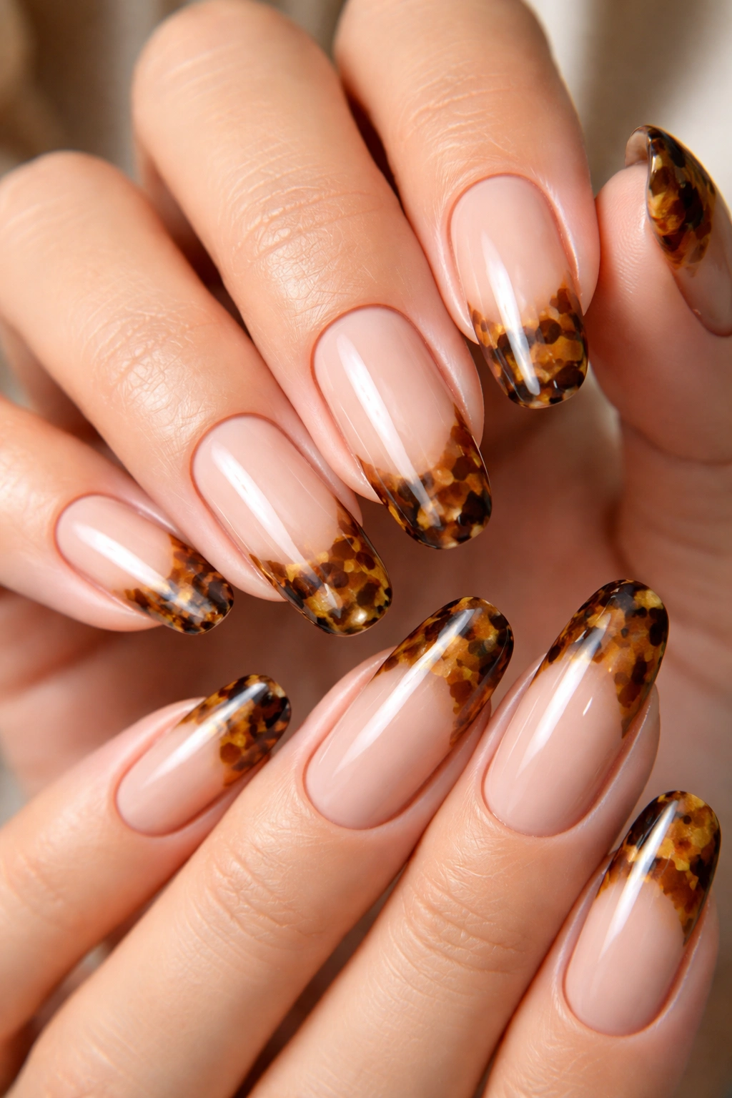 Tortoiseshell French tip nails across brown amber tones