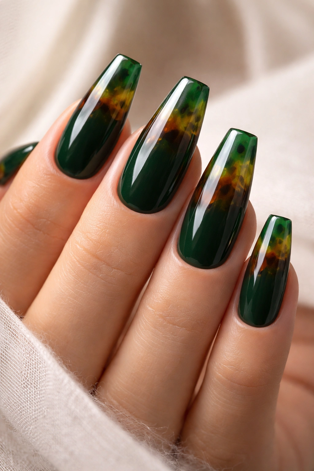 Nails with green tortoiseshell tips over a solid dark green base with high-gloss finish