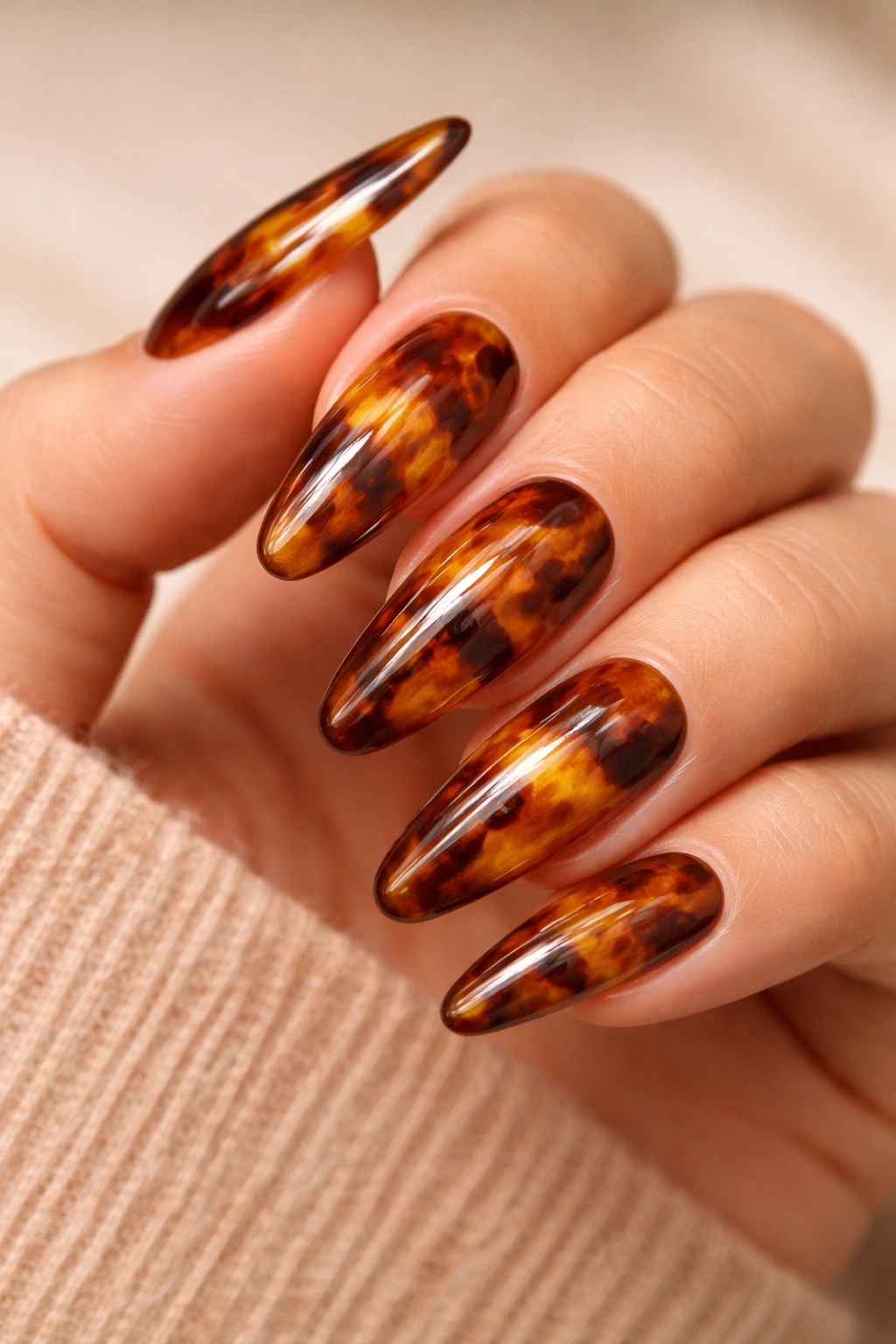 Close-up of tortoiseshell-pattern nails with amber-brown marbling