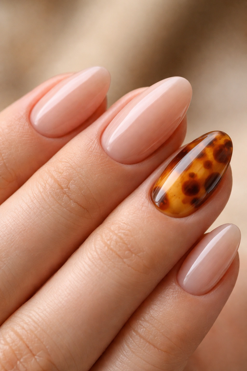 Close-up of almond nails with a translucent tortoiseshell accent on one nail