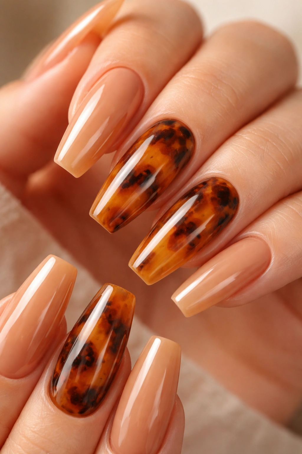 Nails with walnut tortoiseshell panels on a warm brown manicure