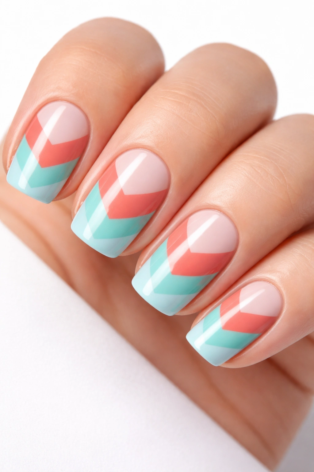 Close-up of tri-color chevron nail design with three diagonal bands